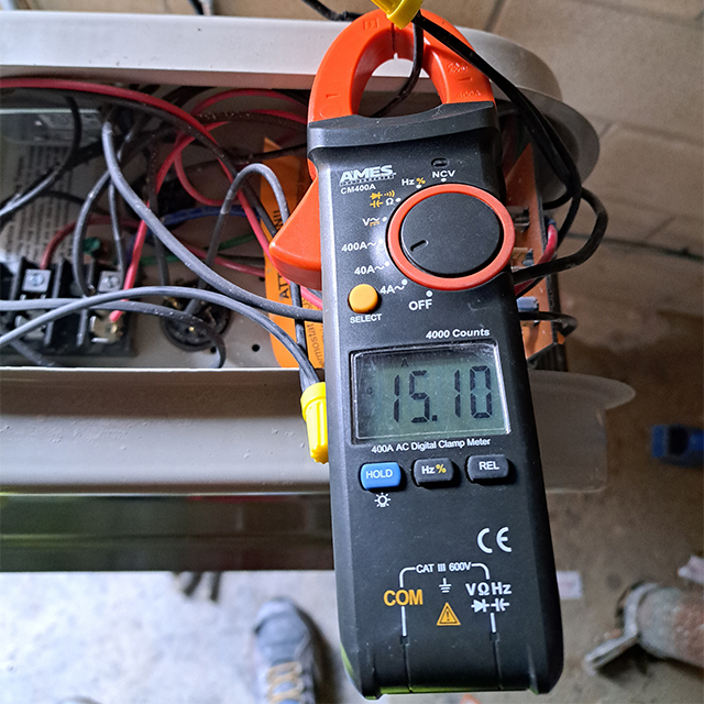 DuoMatic Electric technician checking some wiring using a handheld digitla volt meter